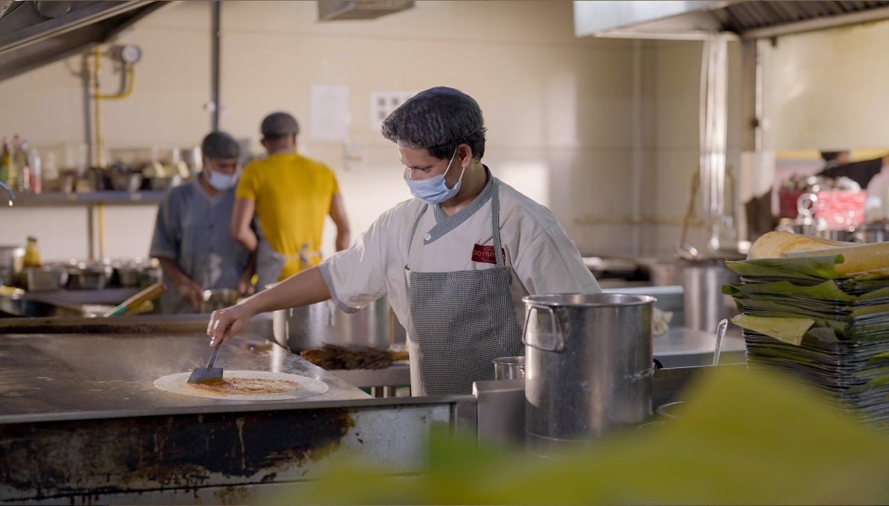 Chef making a beautiful masala dosa in a kitchen